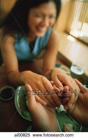 Couple holding hands across table View Large Photo Image Stock Photography - Couple holding hands across table. Fotosearch