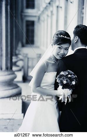 Couple in bridal clothes, woman holding bouquet, portrait View Large Photo Image Stock Photo - Couple in bridal clothes, woman holding bouquet, portrait. Fotosearch