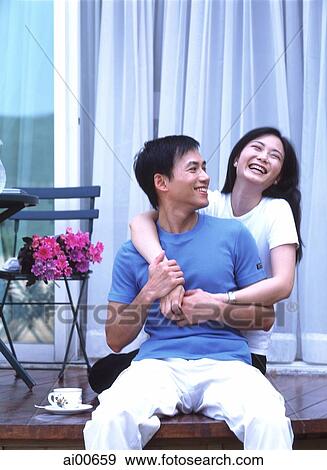 Couple sitting on balcony, embracing and laughing View Large Photo Image Stock Photo - Couple sitting on balcony, embracing and laughing. Fotosearch