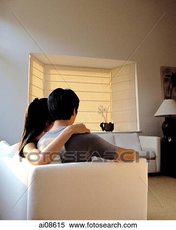Couple sitting on sofa in living room. View Large Photo Image Stock Photography - Couple sitting on sofa in living room.. Fotosearch