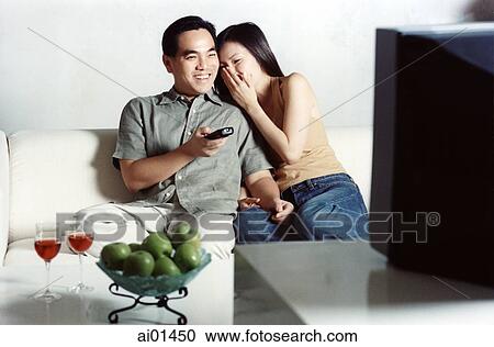 Couple sitting on sofa watching television ( high grain) View Large Photo Image Stock Image - Couple sitting on sofa watching television ( high grain). Fotosearch