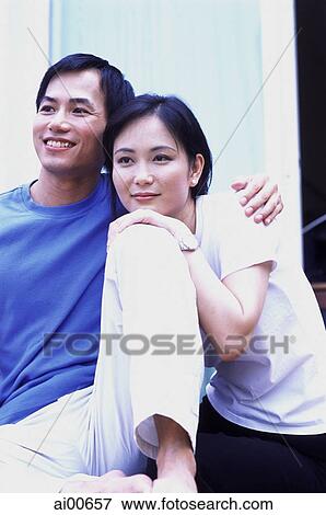 Couple sitting outdoors, in embrace View Large Photo Image Stock Photo - Couple sitting outdoors, in embrace. Fotosearch