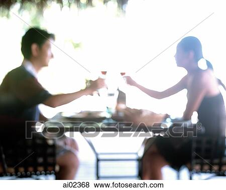 Couple toasting outdoors over table, defocused. View Large Photo Image Stock Photo - Couple toasting outdoors over table, defocused.. Fotosearch