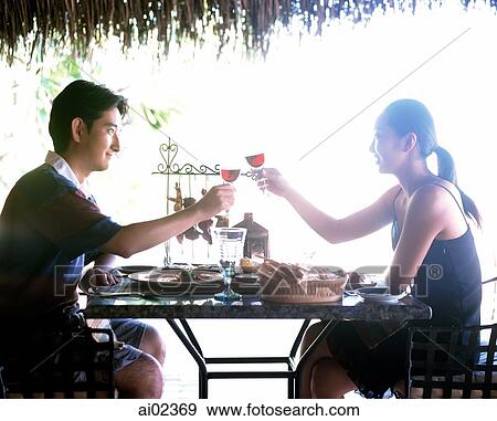Couple toasting outdoors over table. View Large Photo Image Stock Photo - Couple toasting outdoors over table.. Fotosearch
