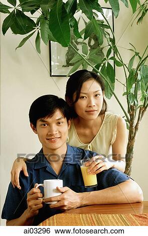 Stock Photograph - Couple with drinks at home, portrait. Fotosearch