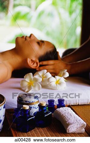 Stock Photo - Eurasian female lying down receiving a head massage, profile. Fotosearch