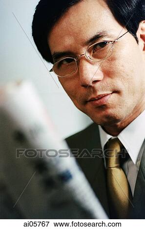 Executive holding newspaper, portrait View Large Photo Image Stock Photo - Executive holding newspaper, portrait. Fotosearch