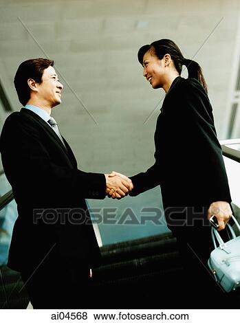 Executive pair shaking hands on escalator. View Large Photo Image Stock Photo - Executive pair shaking hands on escalator.. Fotosearch
