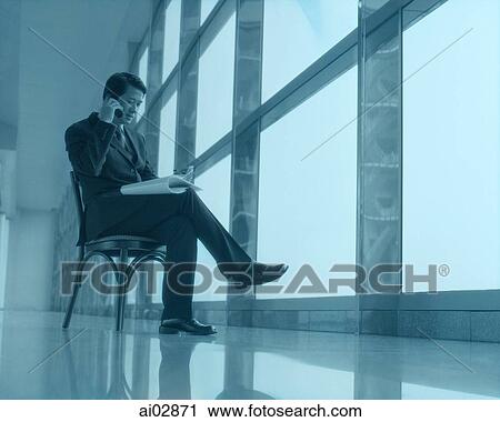 Executive sitting using cellular phone next to window. View Large Photo Image Stock Image - Executive sitting using cellular phone next to window.. Fotosearch