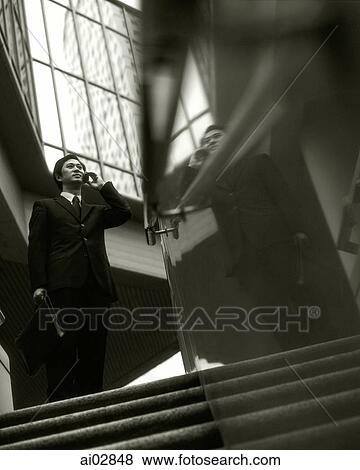 Executive using cellular phone on top of stairs, building in background. View Large Photo Image Stock Photo - Executive using cellular phone on top of stairs, building in background.. Fotosearch