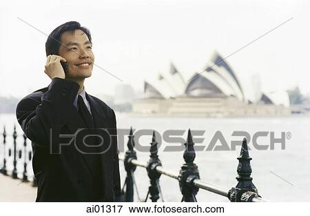 Executive using cellular phone, Sydney Opera House in background View Large Photo Image Stock Photo - Executive using cellular phone, Sydney Opera House in background. Fotosearch