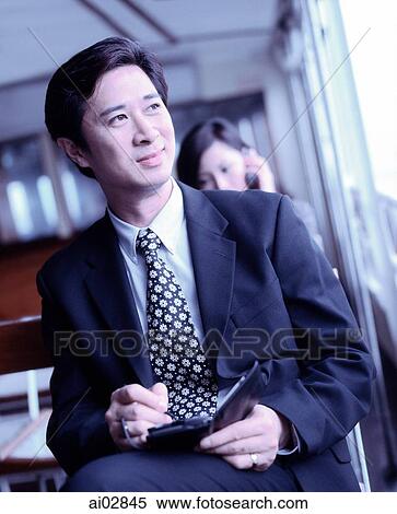 Stock Photography - Executive using PDA on ferry.. Fotosearch