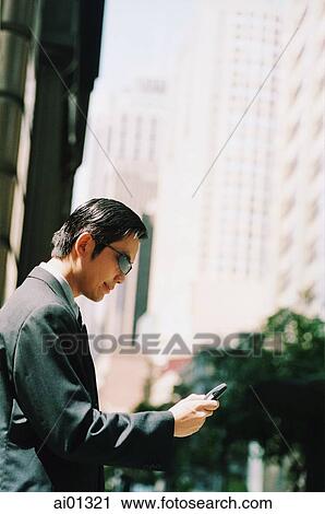 Executive wearing sunglasses dialing cellular phone, buildings in background View Large Photo Image Stock Image - Executive wearing sunglasses dialing cellular phone, buildings in background. Fotosearch