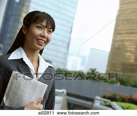 Executive woman holding newspaper, buildings in background. View Large Photo Image Stock Image - Executive woman holding newspaper, buildings in background.. Fotosearch