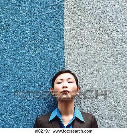 Executive woman with eyes closed standing against split colored background View Large Photo Image Stock Photo - Executive woman with eyes closed standing against split colored background. Fotosearch