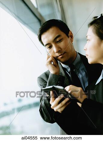 Executives using PDA and cellular phone. View Large Photo Image Stock Photography - Executives using PDA and cellular phone.. Fotosearch
