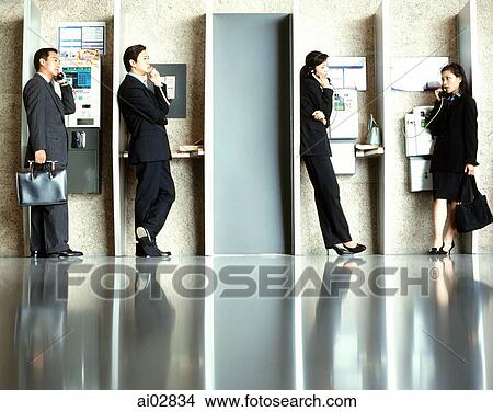 Executives using public telephones. View Large Photo Image Picture - Executives using public telephones.. Fotosearch
