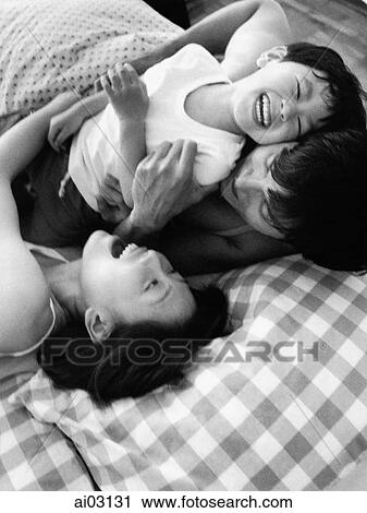 Family playing in bed, laughing View Large Photo Image Stock Image - Family playing in bed, laughing. Fotosearch