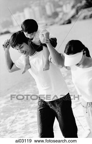 Family walking on beach, son on father's shoulders View Large Photo Image Stock Photo - Family walking on beach, son on father's shoulders. Fotosearch