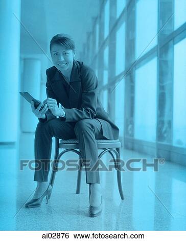 Female executive holding PDA sitting by window, portrait. View Large Photo Image Stock Photograph - Female executive holding PDA sitting by window, portrait.. Fotosearch