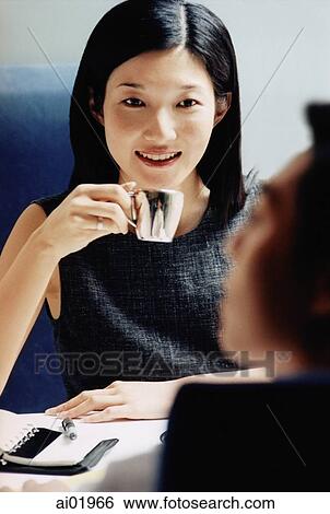 Female executive in cafe, male executive in foreground View Large Photo Image Stock Photograph - Female executive in cafe, male executive in foreground. Fotosearch