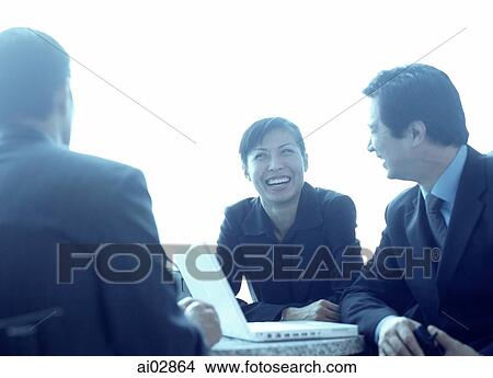 Picture - Female executive laughing with male colleagues.. Fotosearch