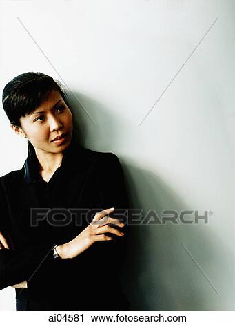 Female executive leaning against wall, looking off camera. View Large Photo Image Stock Image - Female executive leaning against wall, looking off camera.. Fotosearch
