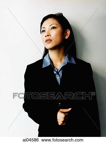 Female executive leaning against wall, looking off camera. View Large Photo Image Stock Photograph - Female executive leaning against wall, looking off camera.. Fotosearch