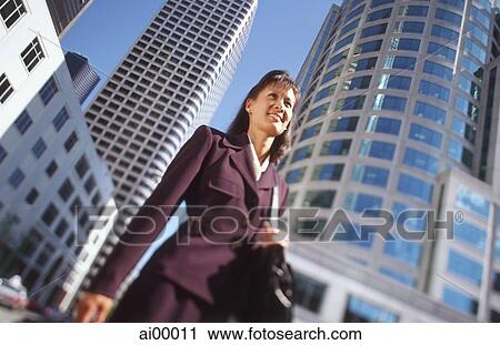 Female executive standing in front of office buildings, low angle view View Large Photo Image Stock Image - Female executive standing in front of office buildings, low angle view. Fotosearch