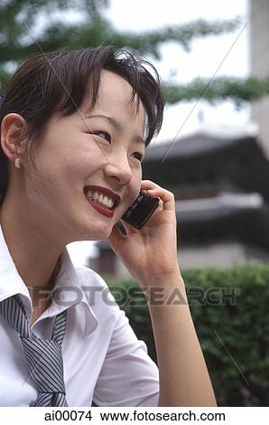Female executive talking on cellular phone, smiling View Large Photo Image Picture - Female executive talking on cellular phone, smiling. Fotosearch