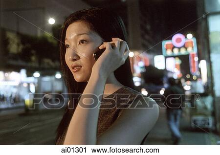 Female executive talking on cellular phone with neon in background View Large Photo Image Stock Image - Female executive talking on cellular phone with neon in background. Fotosearch