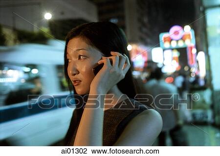 Female executive talking on cellular phone with neon in background View Large Photo Image Stock Image - Female executive talking on cellular phone with neon in background. Fotosearch