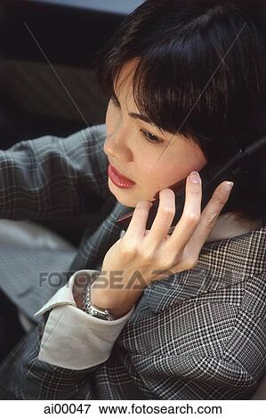 Female executive talking on cellular phone in car View Large Photo Image Stock Photo - Female executive talking on cellular phone in car. Fotosearch