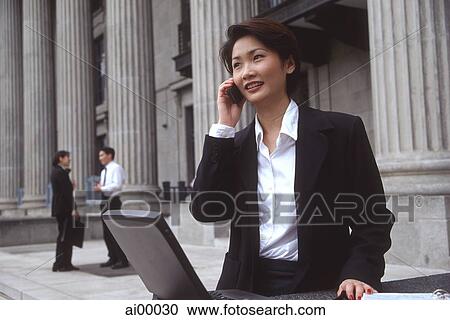 Female executive with laptop computer and cellular phone View Large Photo Image Stock Image - Female executive with laptop computer and cellular phone. Fotosearch