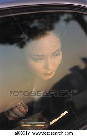Female executive with palmtop computer looking out of car window View Large Photo Image Stock Photo - Female executive with palmtop computer looking out of car window. Fotosearch