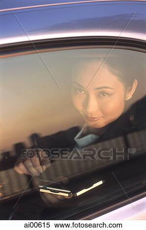 Female executive with palmtop, looking out of car window View Large Photo Image Stock Photography - Female executive with palmtop, looking out of car window. Fotosearch