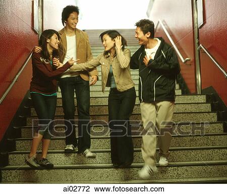 Four young adults walking and laughing down stairs. View Large Photo Image Stock Image - Four young adults walking and laughing down stairs.. Fotosearch