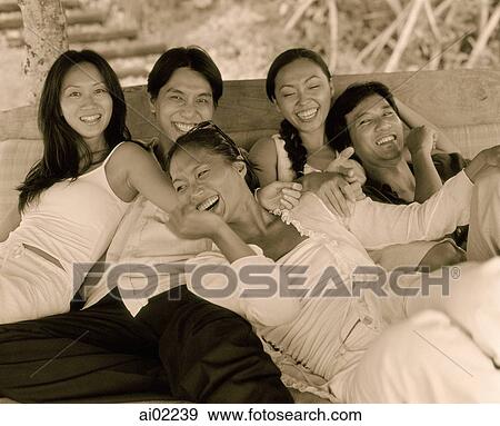 Friends sitting together laughing on couch, outdoors View Large Photo Image Stock Photo - Friends sitting together laughing on couch, outdoors. Fotosearch