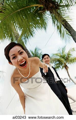Groom holding bride's hand on beach ( high grain) View Large Photo Image Stock Image - Groom holding bride's hand on beach ( high grain). Fotosearch
