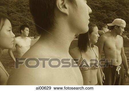 Group of teenagers in swimwear, standing by ocean View Large Photo Image Stock Photo - Group of teenagers in swimwear, standing by ocean. Fotosearch