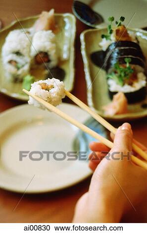Hand holding chopsticks picking up sushi View Large Photo Image Stock Image - Hand holding chopsticks picking up sushi. Fotosearch