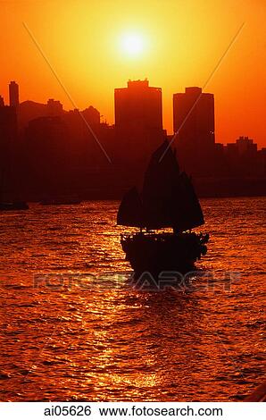 Hong Kong, Victoria Harbor, Silhouette of boat, sun in background. View Large Photo Image Stock Photograph - Hong Kong, Victoria Harbor, Silhouette of boat, sun in background.. Fotosearch