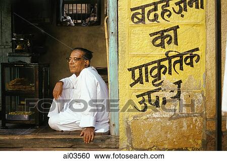 Stock Image - India, Man sitting in doorway. Fotosearch