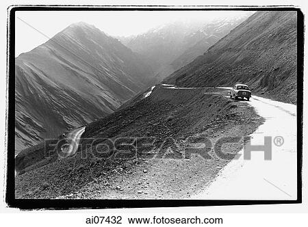 Stock Image - India, Northern India, Srinagar-Leh Road, Car parked along road, mountains at background.. Fotosearch