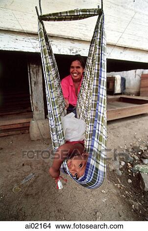 Indonesia, Aceh, Banda Aceh, Mother cares for child in makeshift swing. View Large Photo Image Picture - Indonesia, Aceh, Banda Aceh, Mother cares for child in makeshift swing.. Fotosearch