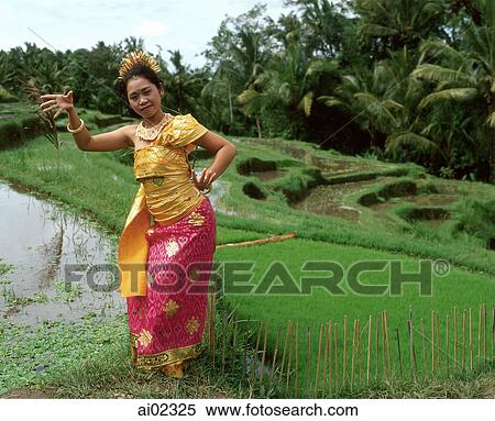Indonesia, Bali, Balinese dancer in padi fields, trees in background View Large Photo Image Stock Photography - Indonesia, Bali, Balinese dancer in padi fields, trees in background. Fotosearch