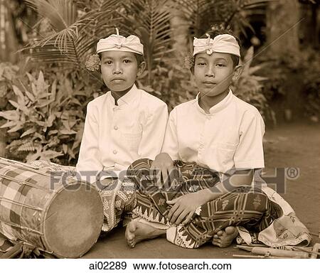 Indonesia, Bali, boys in traditional costumes with hand drum in foreground View Large Photo Image Stock Photo - Indonesia, Bali, boys in traditional costumes with hand drum in foreground. Fotosearch