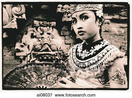 Stock Photo - Indonesia, Bali, Gianyar, Legong dancer holding fan in temple grounds. ( artistic grain). Fotosearch