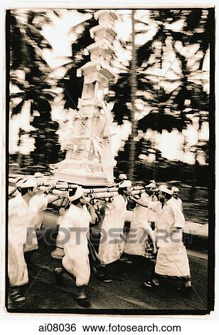Stock Photograph - Indonesia, Bali, Gianyar, Men carrying funeral tower (bade) to temple. (artistic grain). Fotosearch