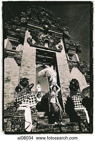 Indonesia, Bali, Gianyar, Women with offerings passing through temple gates. (artistic grain) View Large Photo Image Picture - Indonesia, Bali, Gianyar, Women with offerings passing through temple gates. (artistic grain). Fotosearch